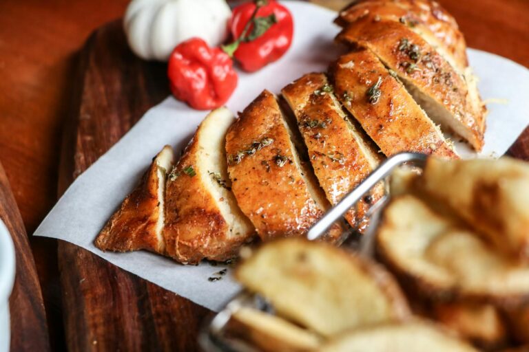 Savory sliced chicken breast with herbs, beautifully styled on a wooden board for culinary appeal.